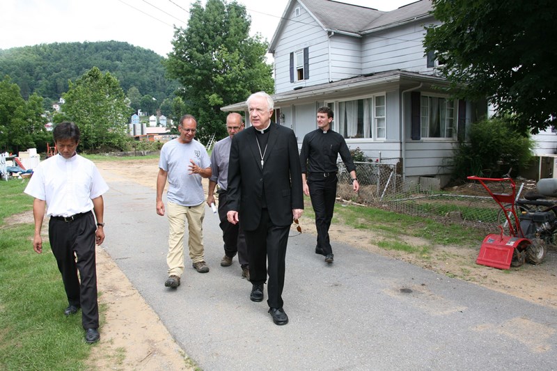 Bishop Michael J. Bransfield tours a flood-devastated neighborhood beside the Cherry River in Richwood, W. Va. With him (l to r) are Father Quy Ngoc Dang SVD, pastor of Holy Family parish in Richwood; Father Arthur Bufogle, pastor of St. John Neumann parish in Marlinton; Rev. Mr. David Galvin of St. James parish in Charles Town; and Father Justin Blanc, priest secretary to the bishop. (Photo by Colleen Rowan/The Catholic Spirit) IMG_9674a